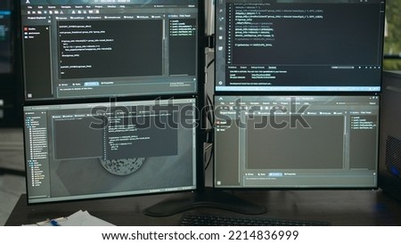 Empty data room with computer screens on desk, computers in background running programming code and algorithms on terminal window. Firewall network servers in it agency office.