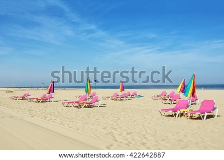 Empty deck chairs on the beach and closed umbrellas.