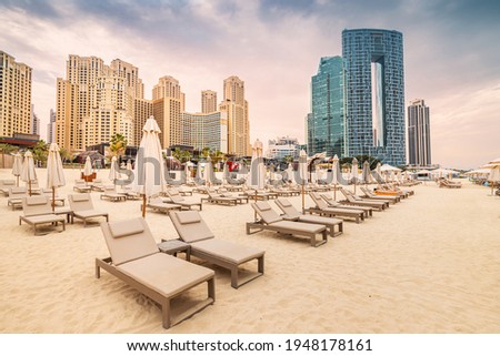 Empty deckchairs with umbrellas and sunbeds at the JBR beach in Dubai. Travel and vacation destinations in United Arab Emirates