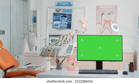 Empty Dental Cabinet With Horizontal Green Screen On Monitor. Nobody In Dentist Office For Dentistry Care With Isolated Background And Mockup Template On Computer. Stomatological Tools