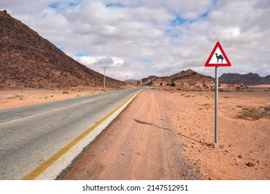 Empty desert road at Wadi Rum, red triangle warning camels sign near - Powered by Shutterstock