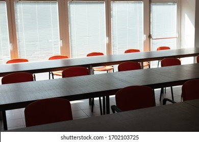 Empty Desks And Chairs In A Deserted Office Room With No People During Corona Virus Pandemic.