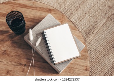 Empty Diary, Notepad Mockup And Book On Round Wooden Table. Glass Of Water And Dry  Lagurus Ovatus Grass. Blurred Beige Rattan Carpet Background. Flat Lay, Top View. Scandinavian Boho Interior.