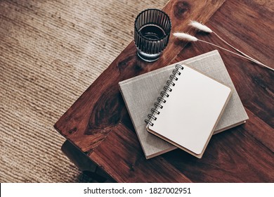 Empty Diary, Notepad Mockup And Book On Wooden Table. Glass Of Water And Dry Bunny Tail Grass. Blurred Beige Jute Carpet Background. Flat Lay, Top View. Simple Scandinavian Boho Interior. 