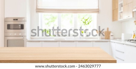 Empty dining table top in blurred interior of modern kitchen