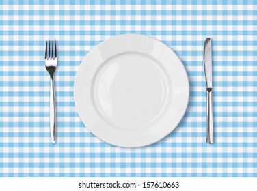 Empty Dinner Plate Top View On Blue Picnic Table Cloth