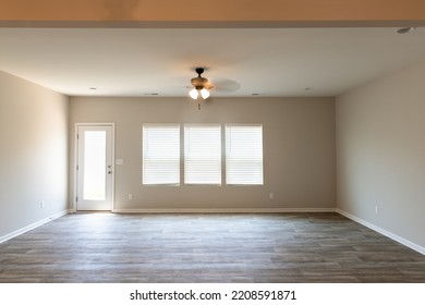 Empty Dinning Room In A Townhouse With Ceiling Fan, A Door, And Window.