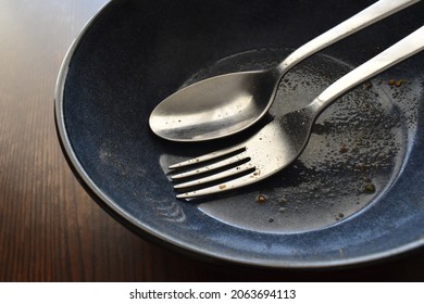 Empty Dirty Bowl With Fork And Spoon After Eating Food.