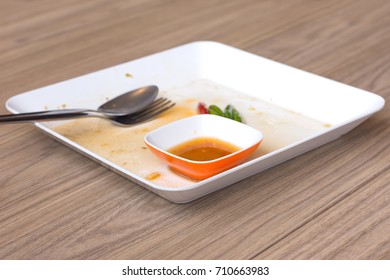 Empty dirty plate with fork, spoon and sauce cup after eaten 