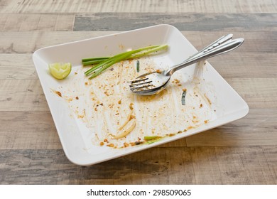 Empty dish but still has spring onion after food on the table