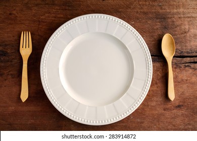 Empty Dish With Wooden Spoon And Fork On Old Wood, Top View