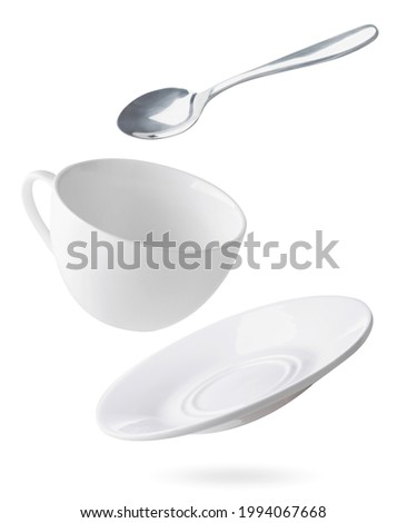 Empty dishes cup, plate and spoon are flying on a white background. Isolated