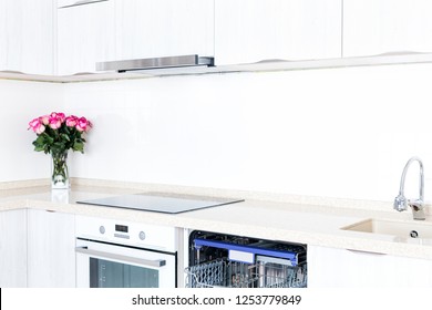 Empty Dishwasher With Opened Door And Beautiful Bouquet Of Flowers Roses On Table, Decorated Kitchen, No People