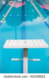 Empty Diving Block Stands In Front Of The Blue Pool Water Looking Straight Down The Race Lane