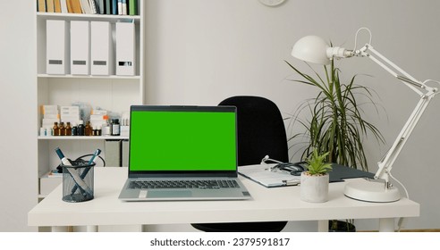 Empty doctor office with a green screen chroma key laptop. No people shot of doctor chamber with laptop in a hospital. - Powered by Shutterstock