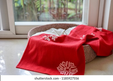 An Empty Dog/cat Bed Basket With Red Christmas Blanket And Copy Space