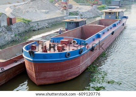 Empty dry cargo barge awaits loading of sand