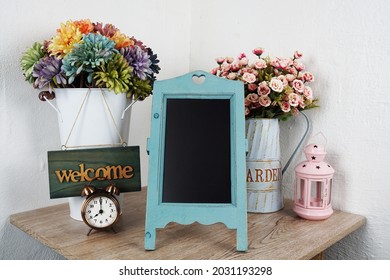 Empty Easel Chalkboard Sign Mockup With Alarm Clock And Flower Decoration