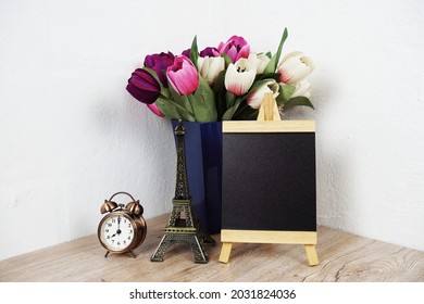 Empty Easel Chalkboard Sign Mockup With Alarm Clock, Eiffel And Flower Decoration