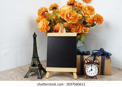 Empty Easel Chalkboard Sign Mockup With Alarm Clock, Eiffel And Flower Decoration