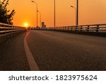empty elevated asphalt road on bridge in modern city during sunset.