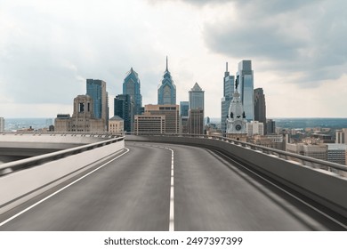 Empty elevated road curving towards a city skyline with modern skyscrapers under an overcast sky. Concept of urban infrastructure and cityscape - Powered by Shutterstock