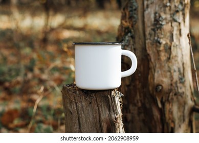 Empty Enamelled Camping Mug Mock Up Standing On Tree Stump In Woods Outdoors. Blank New Metal Cup For Logo Or Branding, Close-up.