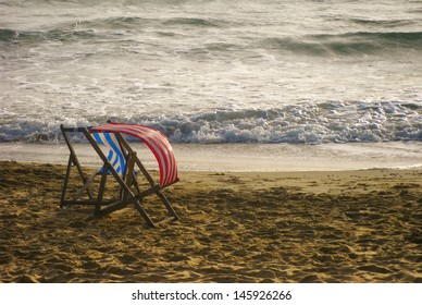 Empty English Beach With Sand, Sea And Windswept Deck Chairs