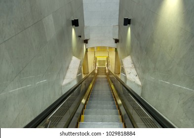 empty escalator and stairs going down in subway at railway station, airport, office building or department store shopping mall, interior, transportation, rush hour and travel concept