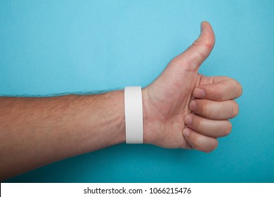 Empty Event Ticket Wrist Band Design. White Blank Paper Wristband, Bracelet Mockup On Blue Background.