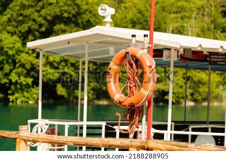 Empty excursion boat moored to pier on lake surrounded by green trees. Touristic ship ready to bring new tourists on Plitvice lakes closeup