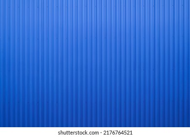 Empty exterior wall of warehouse made of Blue Corrugated metal texture surface or galvanize steel wall industrial building. Stainless steel, metal floor texture metallic background seamless.