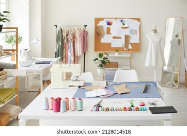 Equipo de moda vacío de diseñador o costurera con hilos y máquina de coser sobre la mesa. No hay gente en su propio taller elegante de sastre o costurero. Diseño de ropa. Estilo y costura.