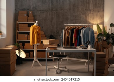 An empty fashion design studio showcases a work desk, mannequin with a yellow jacket, and racks of stylish clothing - Powered by Shutterstock