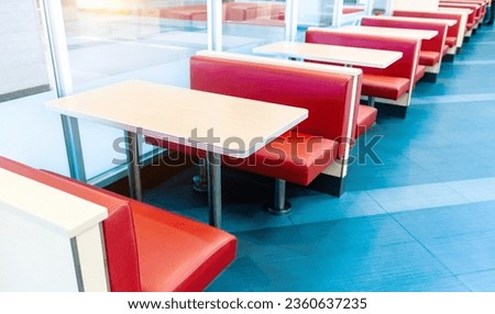Empty fastfood restaurant interior with red chairs and table in a row