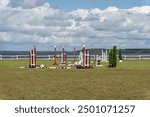 Empty field for horse jumping event competition. Colorful photo of equestrian obstacles.
