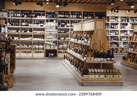 Empty fine modern wine aisle rows in alcohol beverage department at supermarket store grocery shop inside hypermarket. Purchasing food gastronomy, urban lifestyle, consumerism and marketing concept