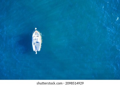 Empty fishing boat from above in atlantic. Aerial view of small white ship on blue sea water. Isolated object.