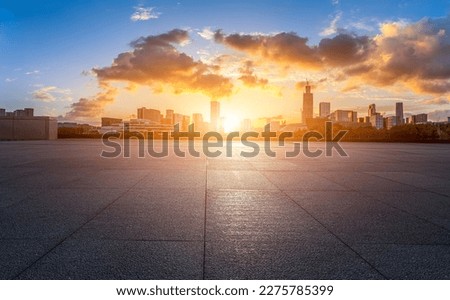 Empty floor and modern city skyline with buildings at sunset