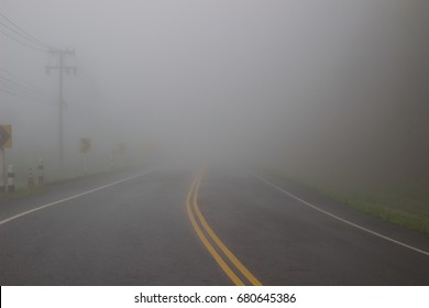 Empty foggy road and low visibility. Show misty and mystery background, fear and horror, Journey and adventure, Unexpected and obstacle in business concept, Safety driving on the road traffic concept.