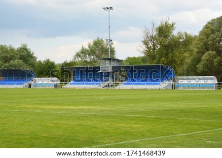 Empty football field with blue stands and seats
