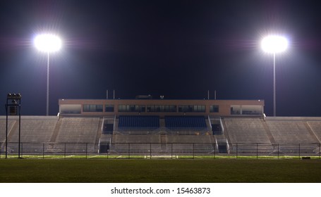 Empty Football Stadium At Night With The Lights On