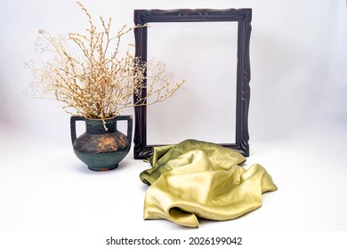 Empty Frame Mock Up With A Green Silky Scarf And A Vintage Vase With Dried Flower And Branches