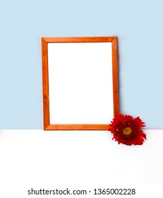 Empty frame mockup for design presentation, red flower on light blue wall and table. Minimalism design