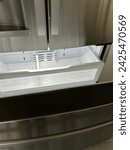 An empty freezer drawer in a stainless steel fridge, food desert concept