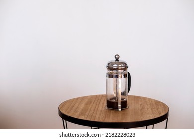 Empty French Press On A Wooden Round Table 