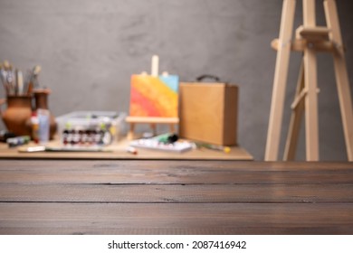 Empty front view of wood table and artist tools. Paintbrush and art painter supplies on desk background texture. Painting in artist workplace