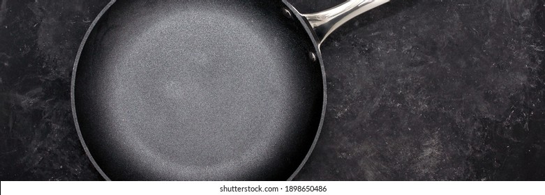 Empty Frying Pan, Top View. Cast Iron Fry Pan On Black Background. New And Clean Frying Pan On Black Table Overhead View.