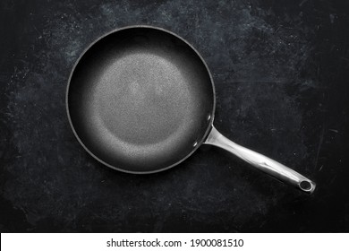 Empty Frying Pan, Top View. Cast Iron Fry Pan On Black Background. New And Clean Frying Pan On Black Table Overhead View.