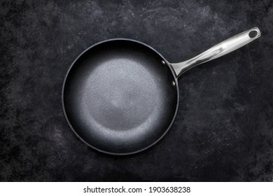 Empty Frying Pan, Top View. Cast Iron Fry Pan On Black Background. New And Clean Frying Pan On Black Table, Overhead View.